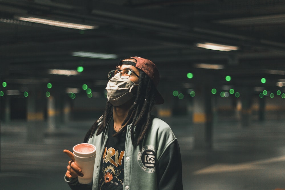 man in white hoodie holding white ceramic mug