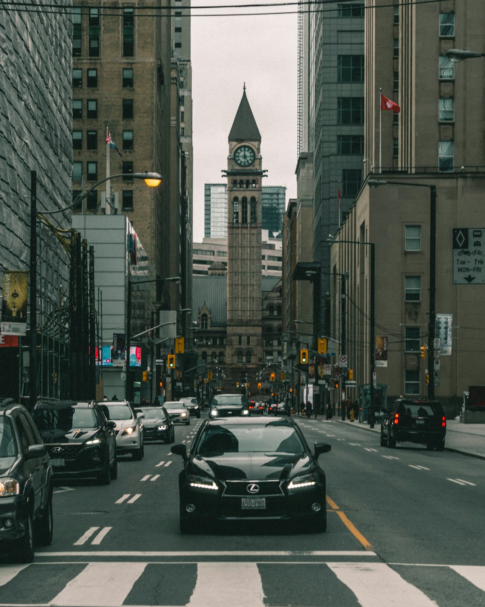 black car on road in between high rise buildings during daytime