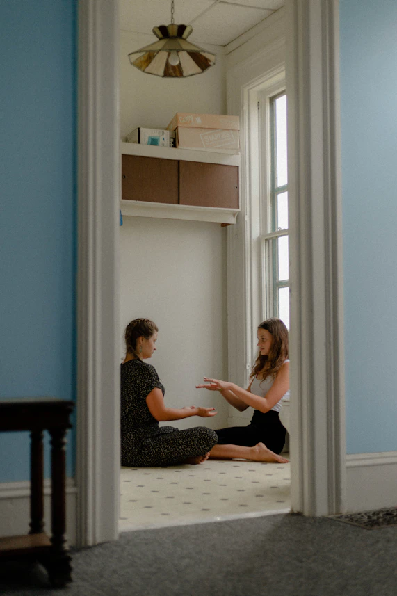 A caring therapist working one-on-one with a young student in a bright, welcoming learning space.