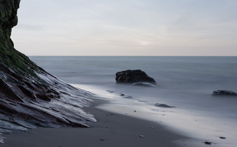 gray rock formation on sea shore during daytime