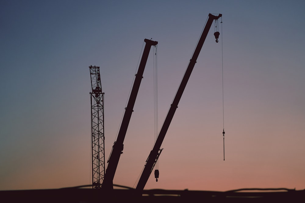 silhouette of crane under blue sky during daytime