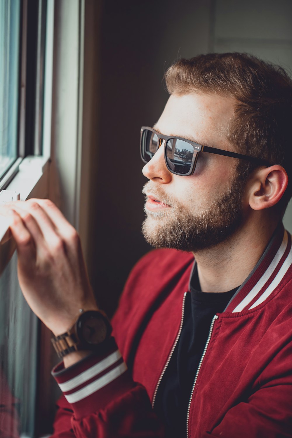 man in black framed eyeglasses and red and black crew neck shirt