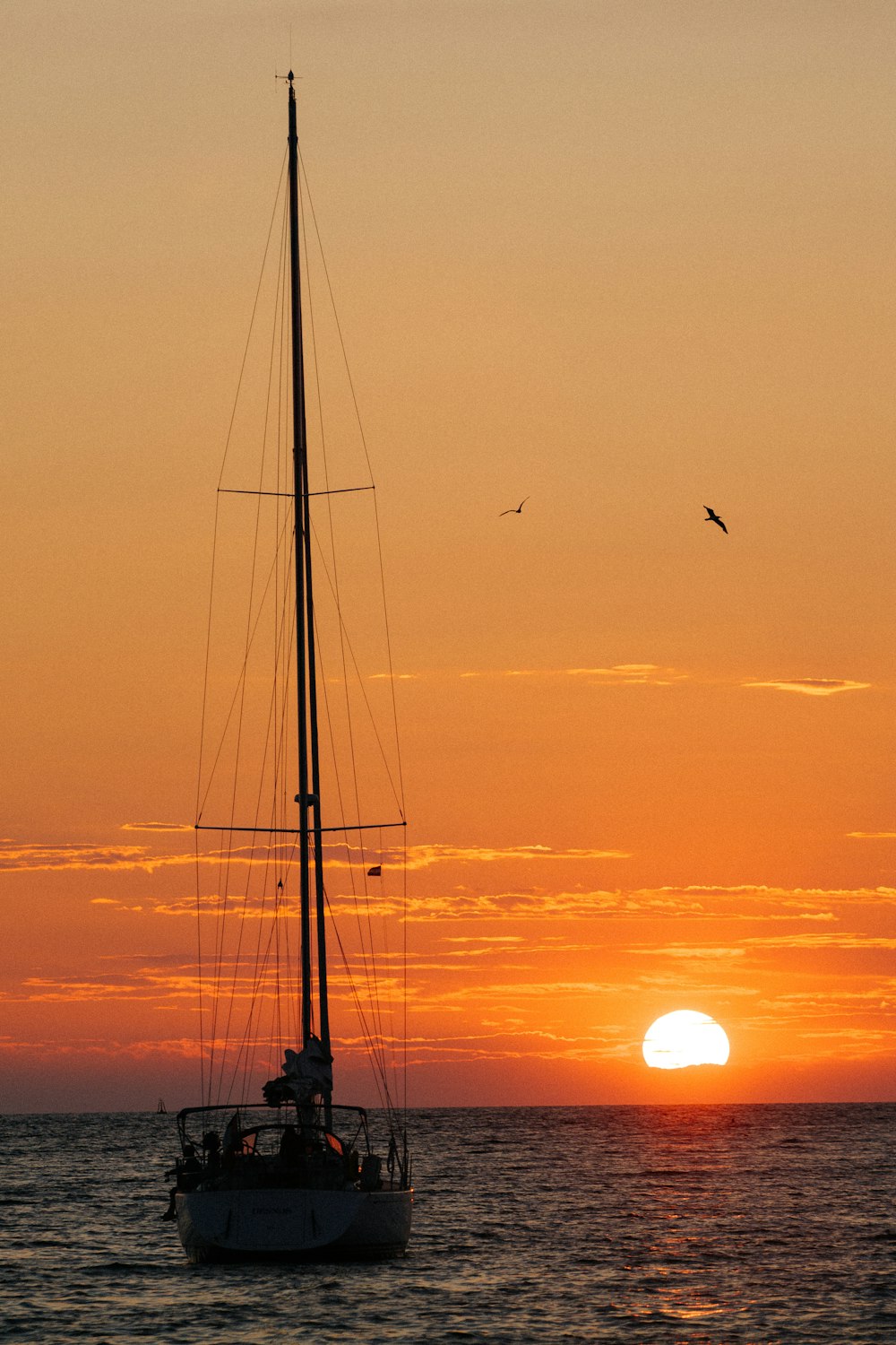 silhouette of sailboat on sea during sunset