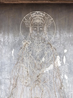 Close-up of a vibrant spiritual artwork created from delicate strands of hair intertwined with colorful pigments.