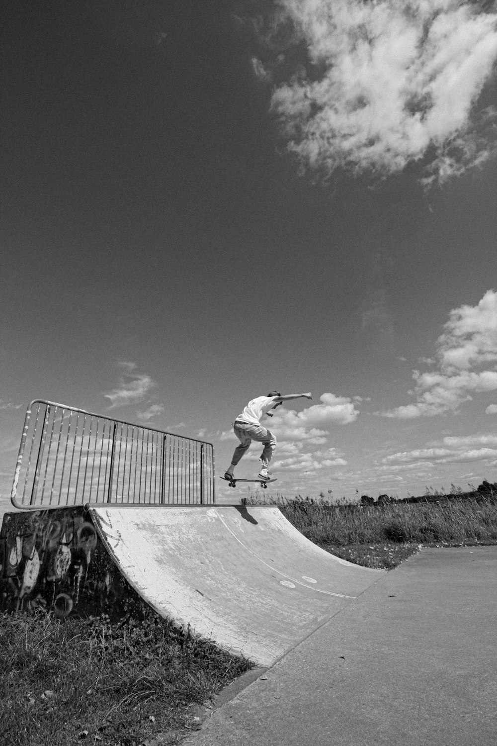 grayscale photo of man riding skateboard