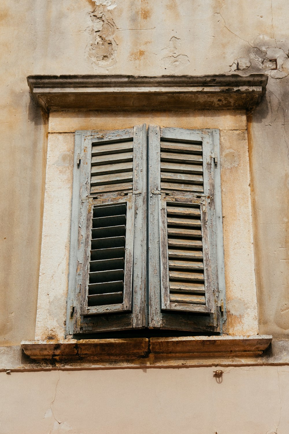 blaues Holzfenster an brauner Betonwand