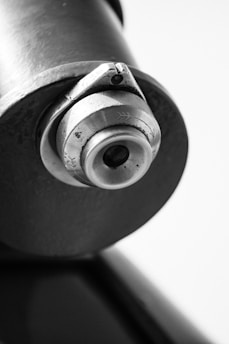 Close-up of a heavy-duty hydraulic cylinder with polished metal surfaces and industrial background.
