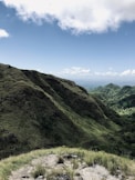 green grass covered mountain under blue sky during daytime