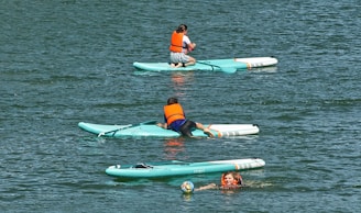 2 women in blue and red bikini on green and white inflatable float on water during