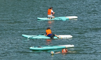 2 women in blue and red bikini on green and white inflatable float on water during