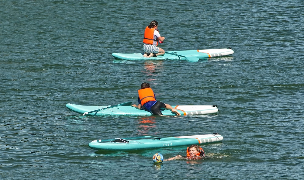 2 women in blue and red bikini on green and white inflatable float on water during