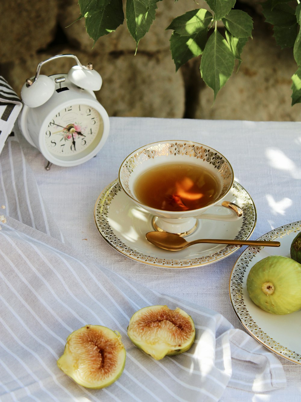white ceramic teacup on saucer beside green apple fruit