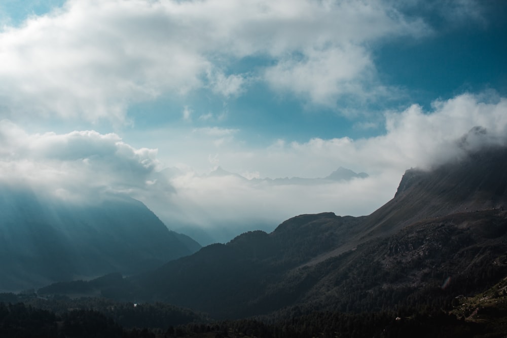 green mountains under white clouds and blue sky during daytime