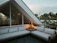 A cozy outdoor patio featuring a verdeluxe HDPE sectional sofa with lush greenery around.