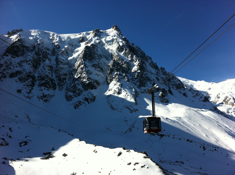 black cable car over snow covered mountain