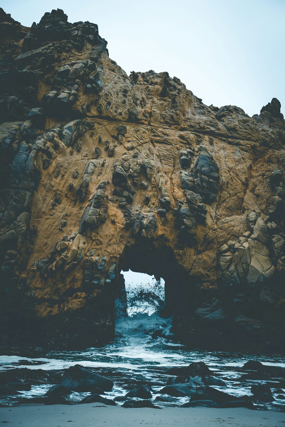 brown rock formation on blue sea under blue sky during daytime