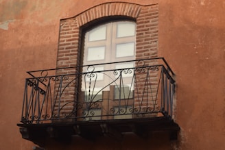 black metal window frame on brown brick wall