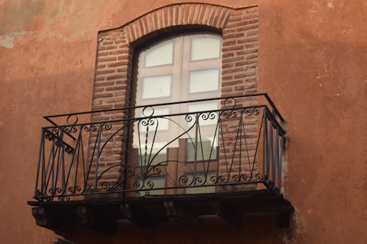 black metal window frame on brown brick wall