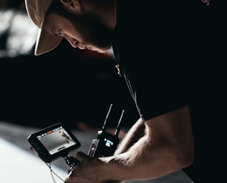 man in black t-shirt holding black dslr camera