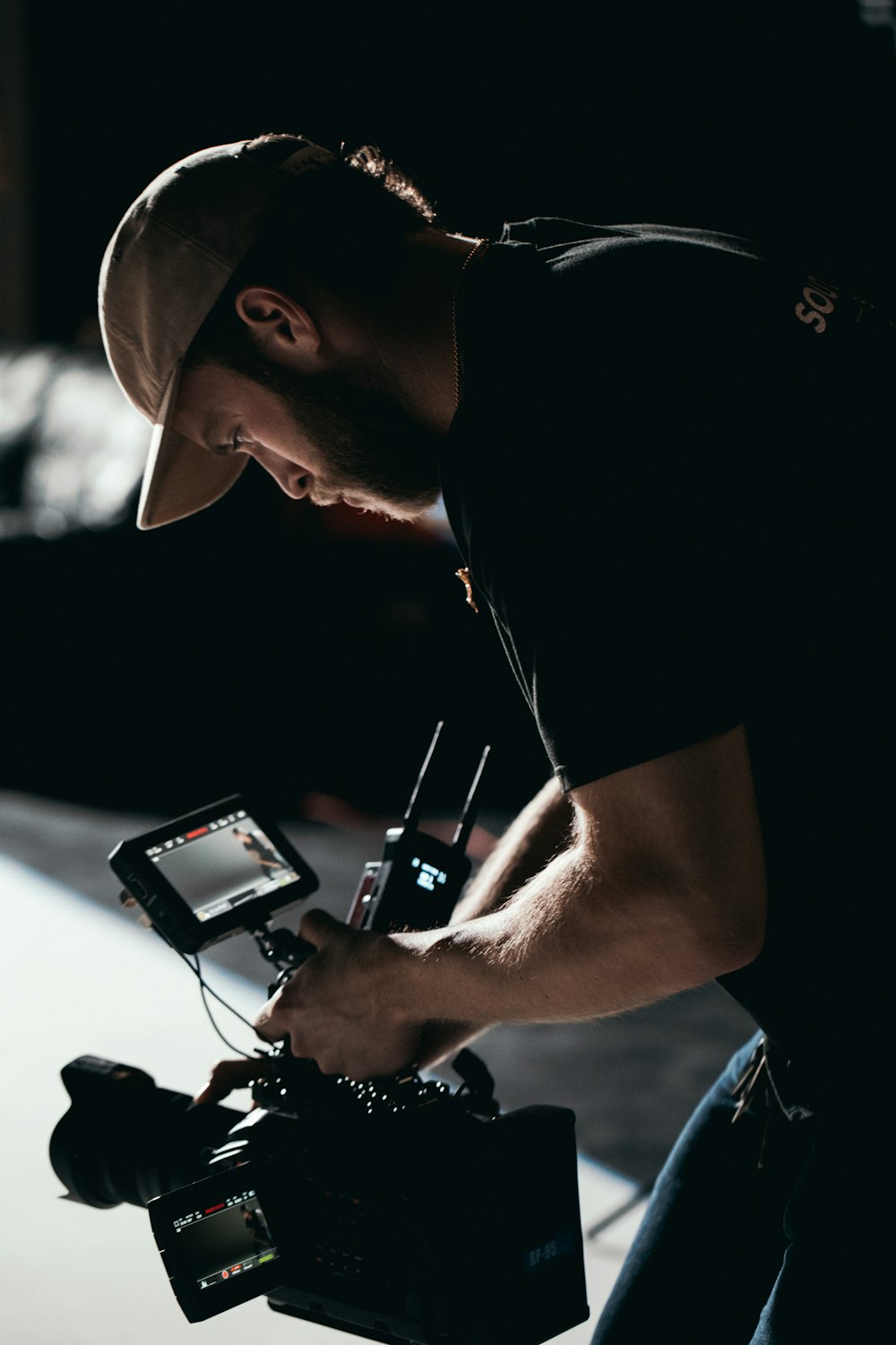 man in black t-shirt holding black dslr camera