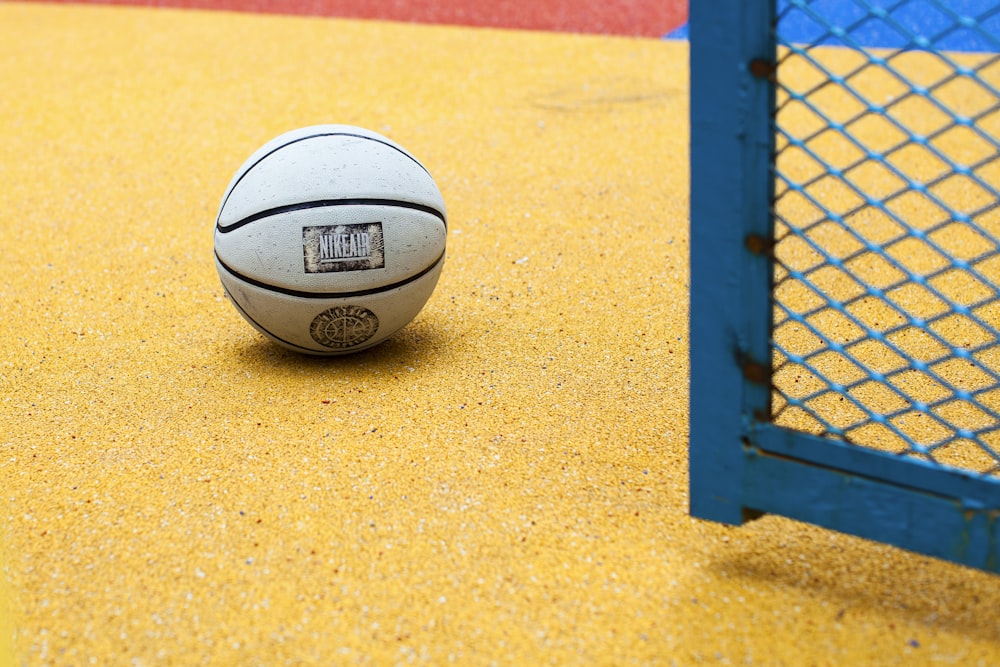 white and black basketball on yellow field