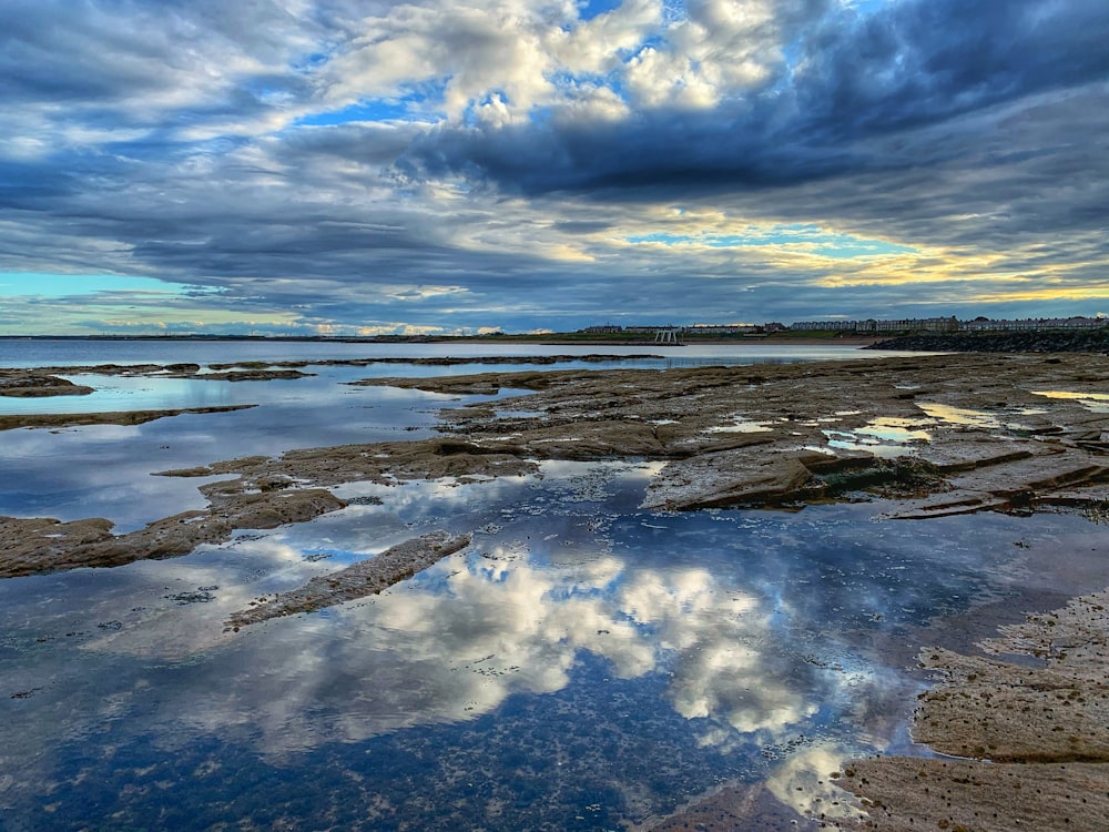 body of water under cloudy sky during daytime