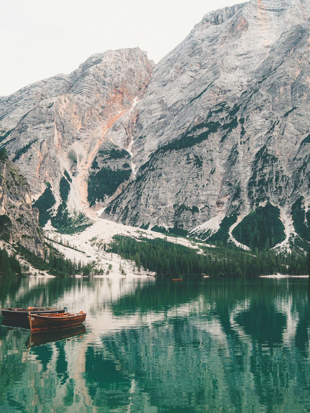 brown boat on lake near mountain during daytime