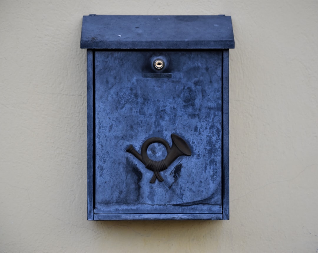 blue wooden door with black steel door lever, a blue colorful mailbox