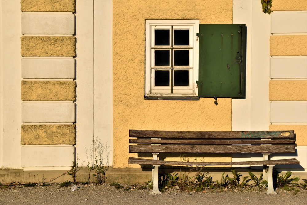 brown wooden bench beside window