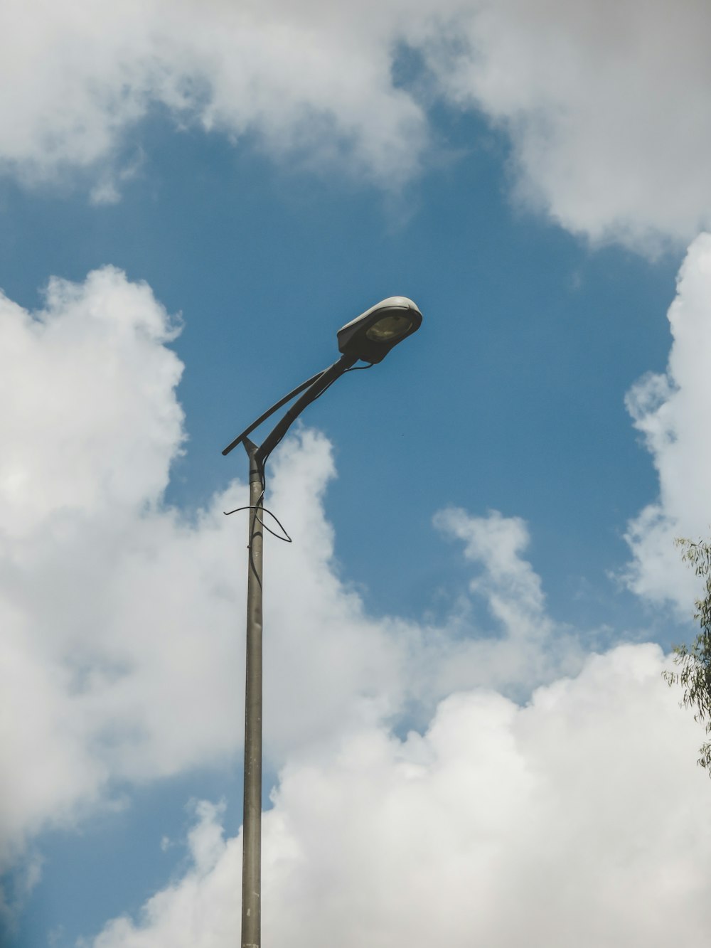 white and black street light under blue sky and white clouds during daytime