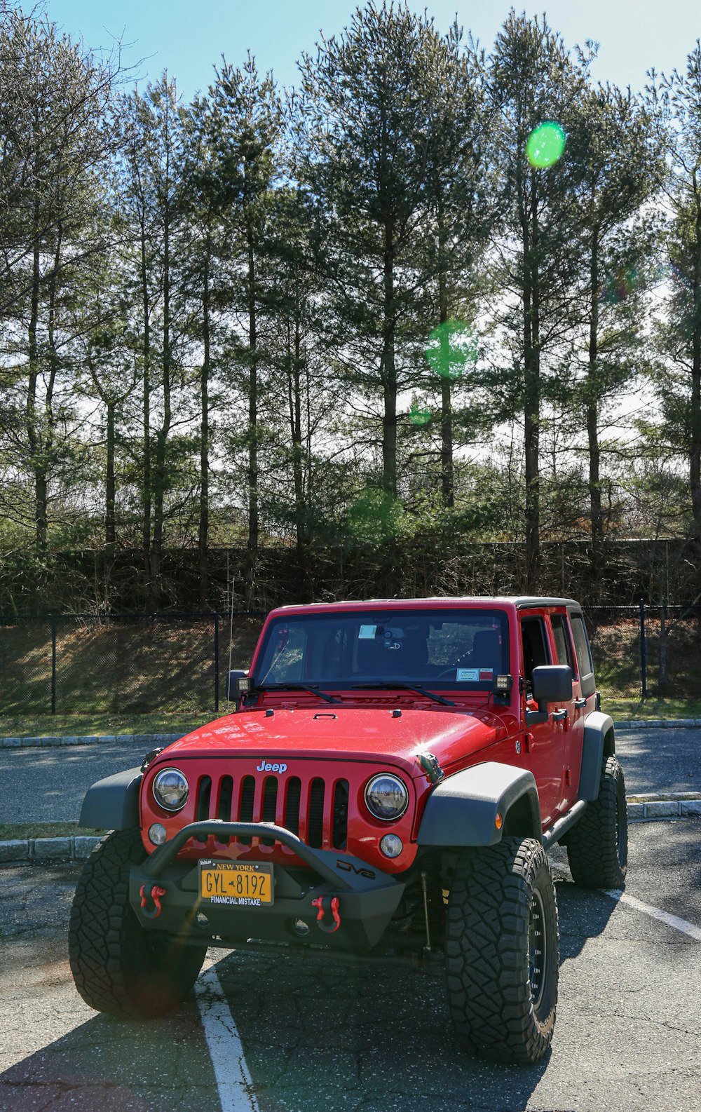 Jeep Wrangler rossa sulla foresta durante il giorno