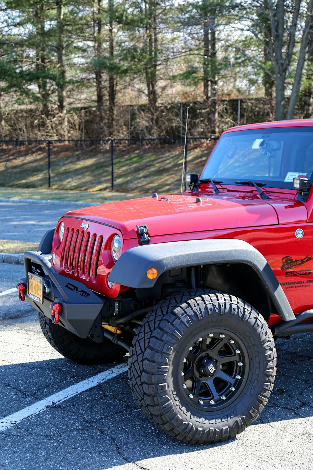 Jeep Wrangler rossa su strada durante il giorno