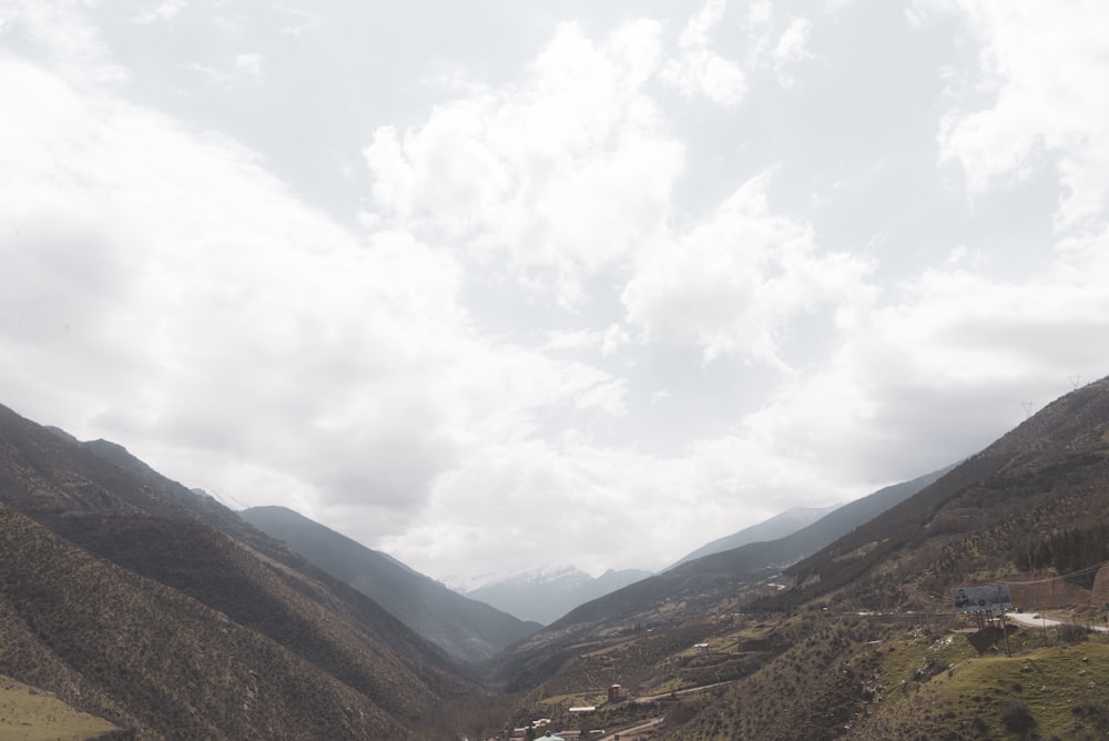 brown and green mountains under white clouds