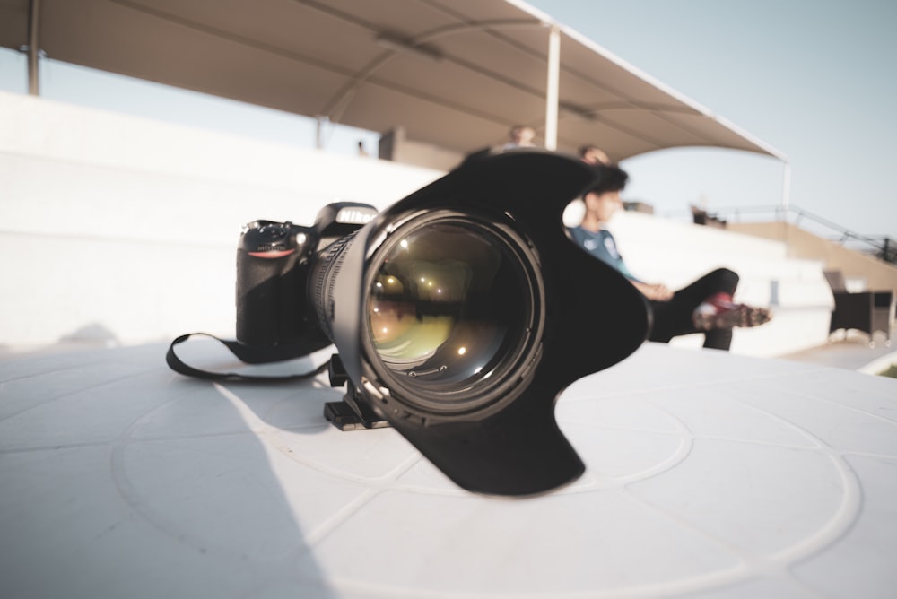 obiettivo della fotocamera nero su tavolo bianco