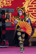 woman in black and yellow dress holding red umbrella