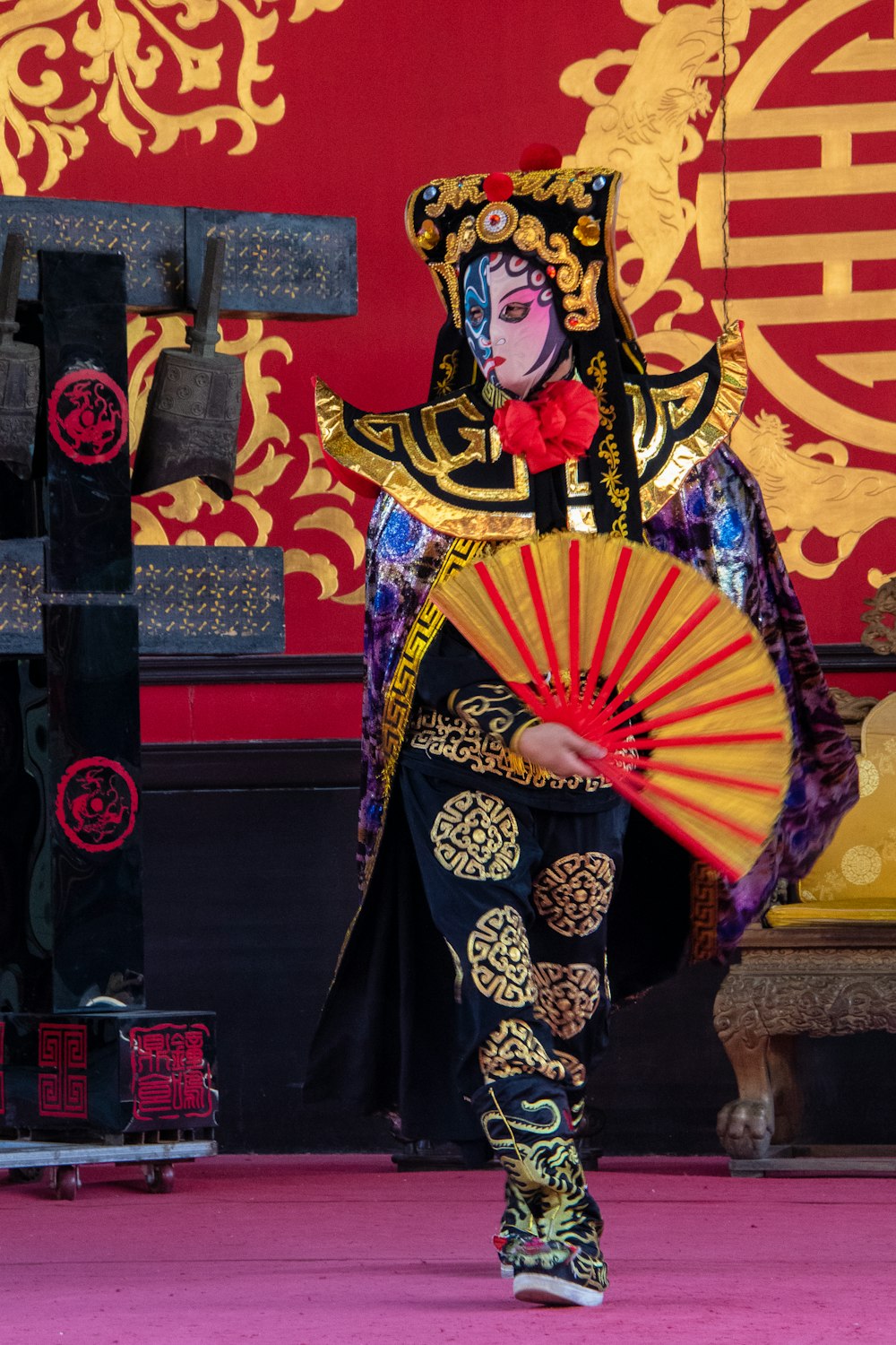 woman in black and yellow dress holding red umbrella