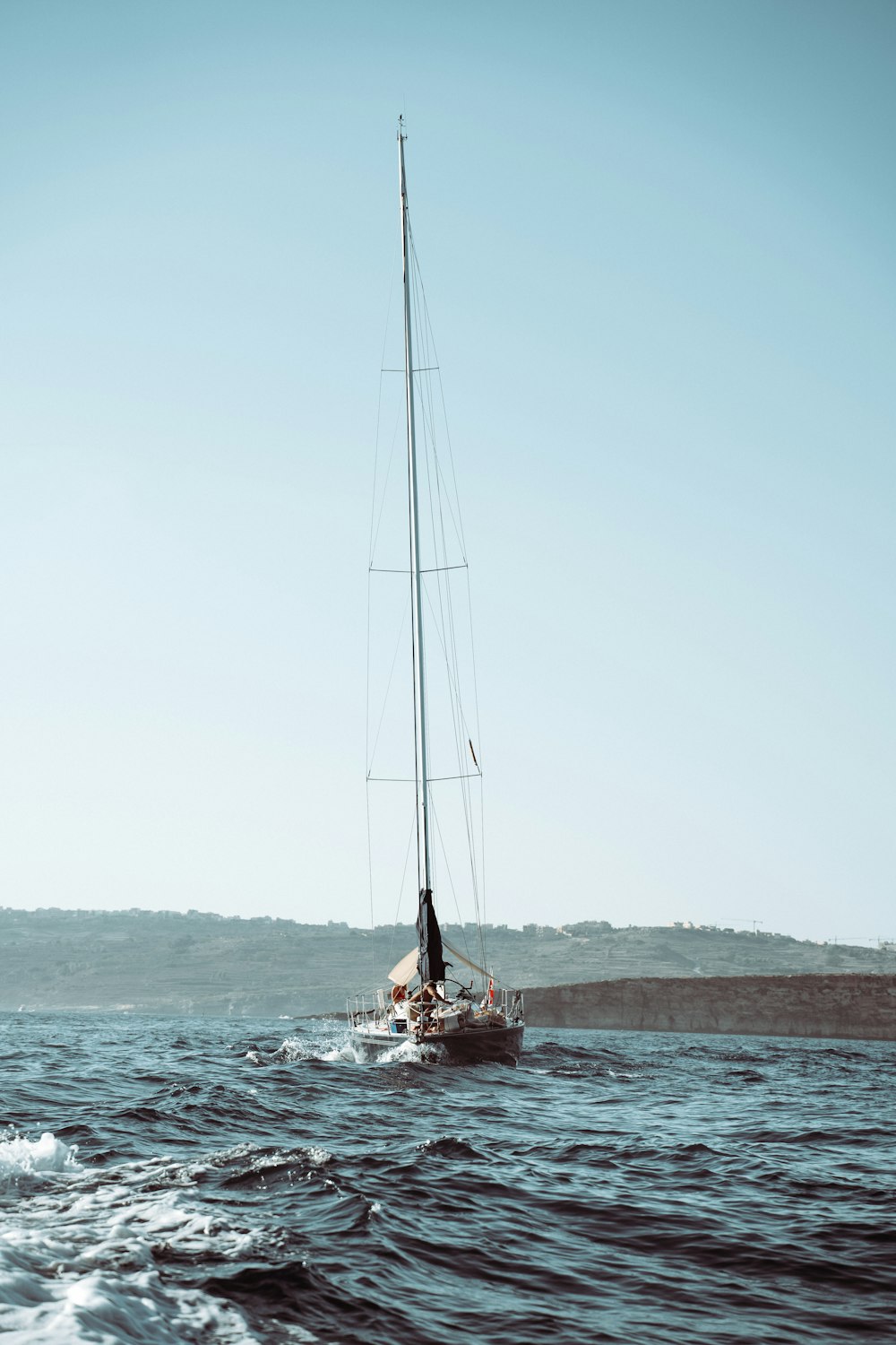 red and white sail boat on sea during daytime