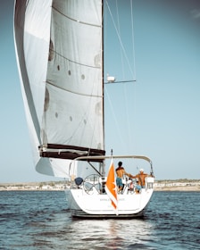 white sail boat on sea during daytime
