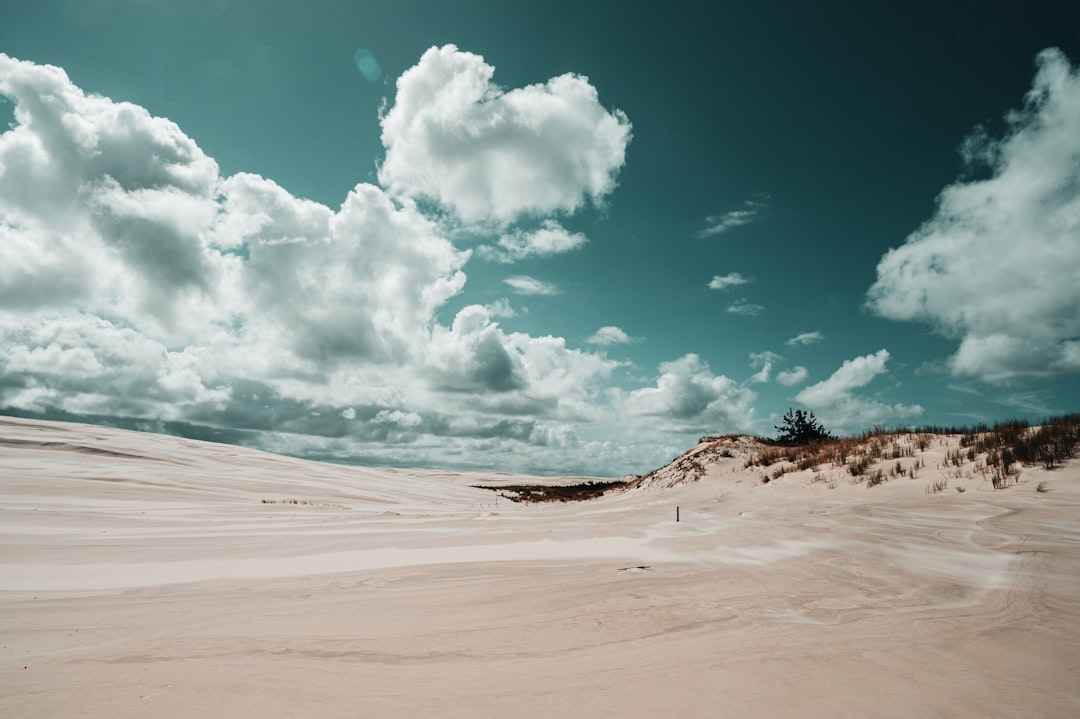 white sand under blue sky and white clouds during daytime