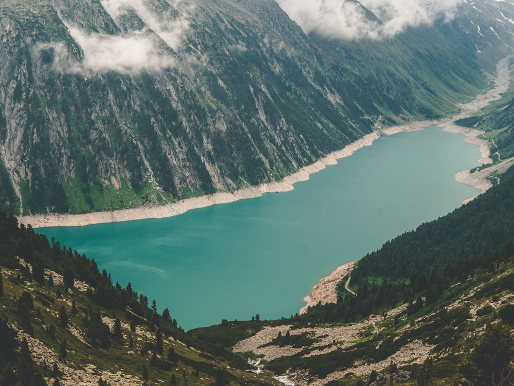 green and black mountains beside body of water during daytime