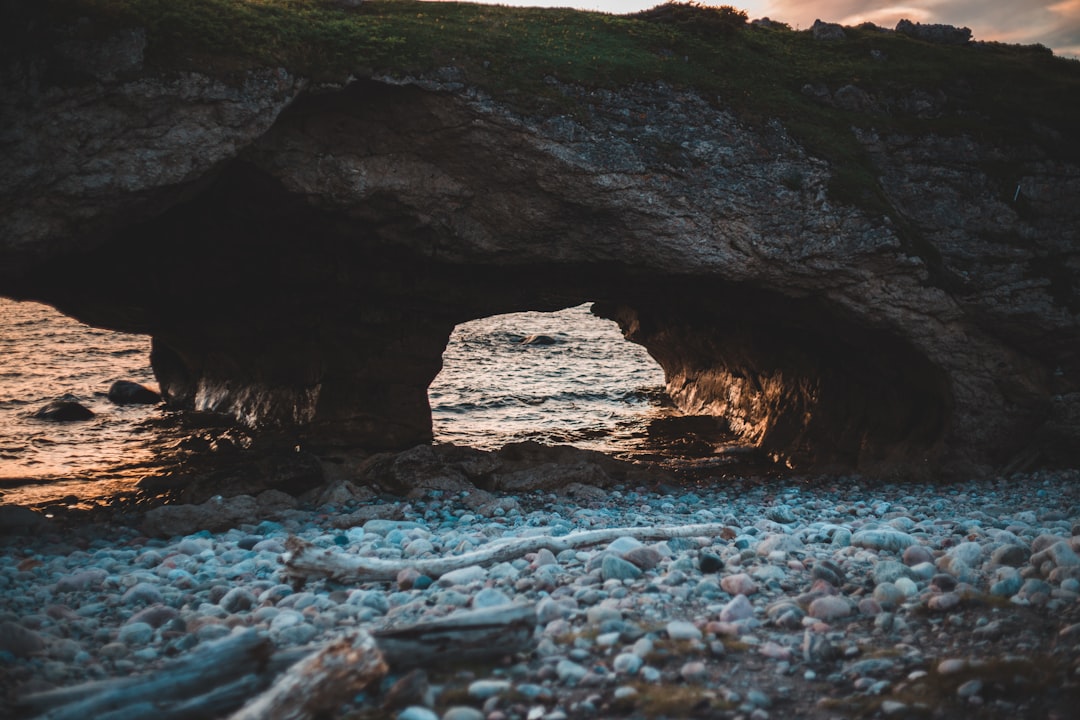 brown rock formation on body of water during daytime