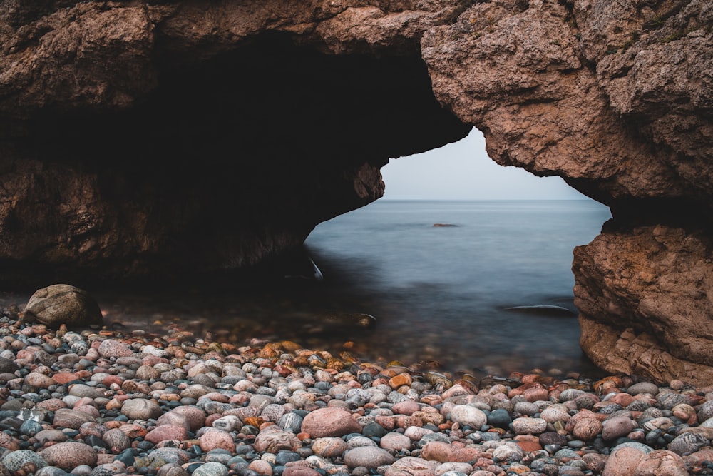 brown rock formation near body of water during daytime