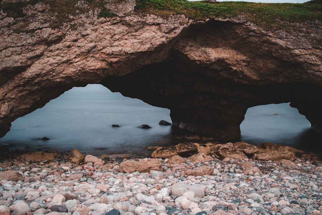 brown rock formation near body of water during daytime