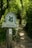 A wooden post with a sign indicates a pathway leading through a lush, green wooded area. The sign reads 'The National Trust' and 'Devil's Dyke' with a small secondary sign indicating access land.