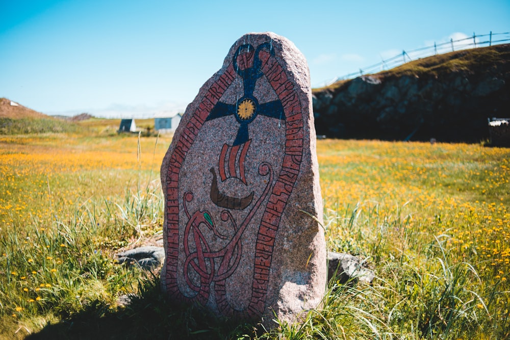 red and black tribal textile on green grass field during daytime