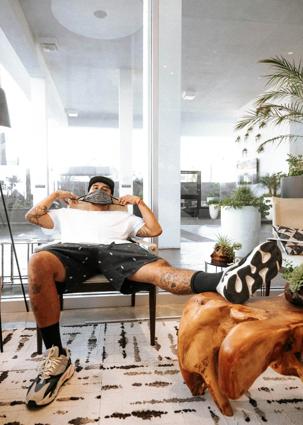 man in black shorts sitting on brown wooden armchair