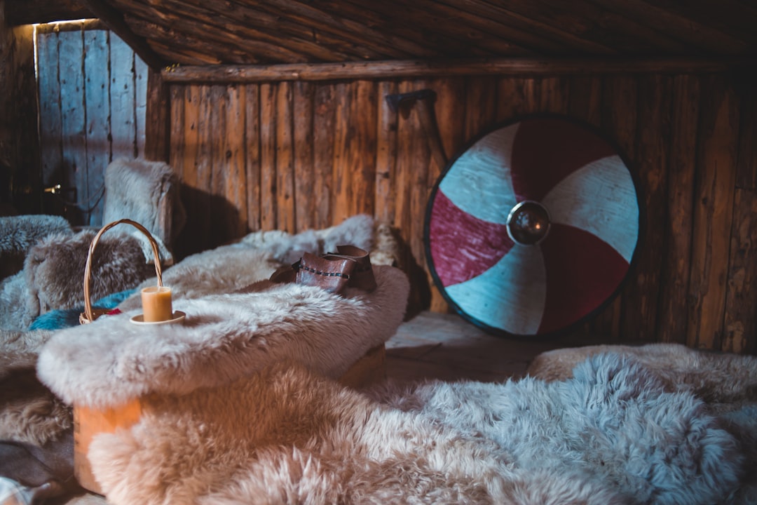 white fur textile beside brown wooden wall