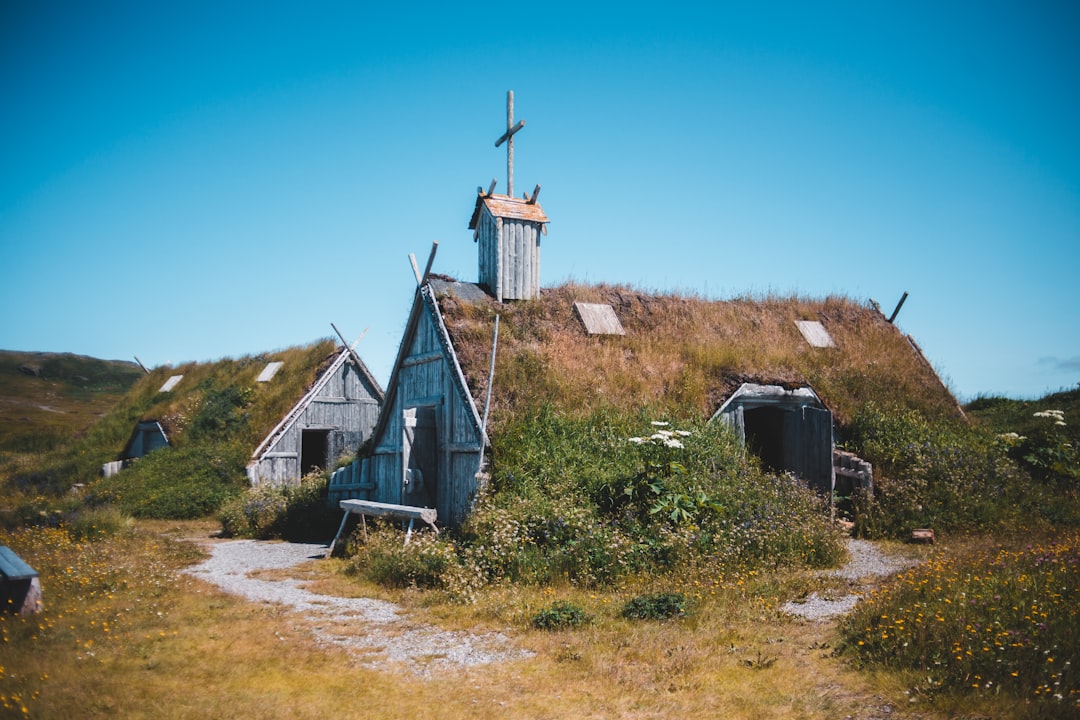 white and brown church on green grass field under blue sky during daytime