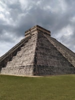 gray concrete building on green grass field under gray cloudy sky during daytime