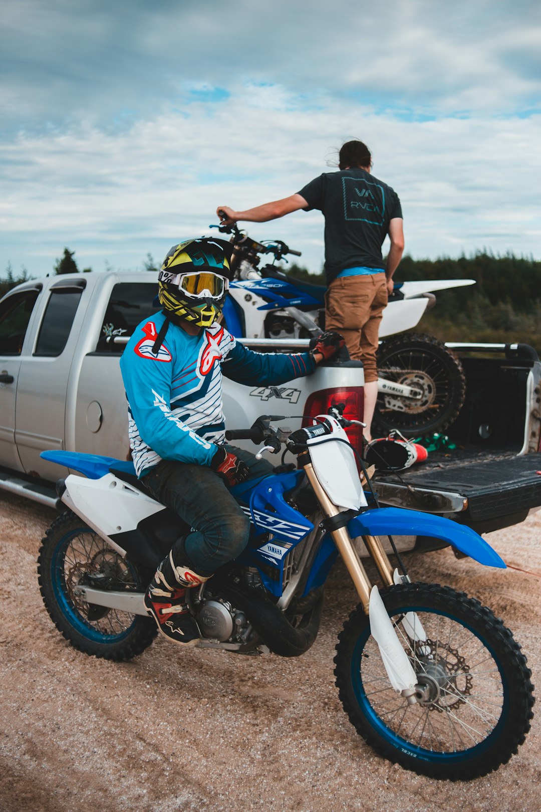 man in blue and white long sleeve shirt riding on blue and white motocross dirt bike